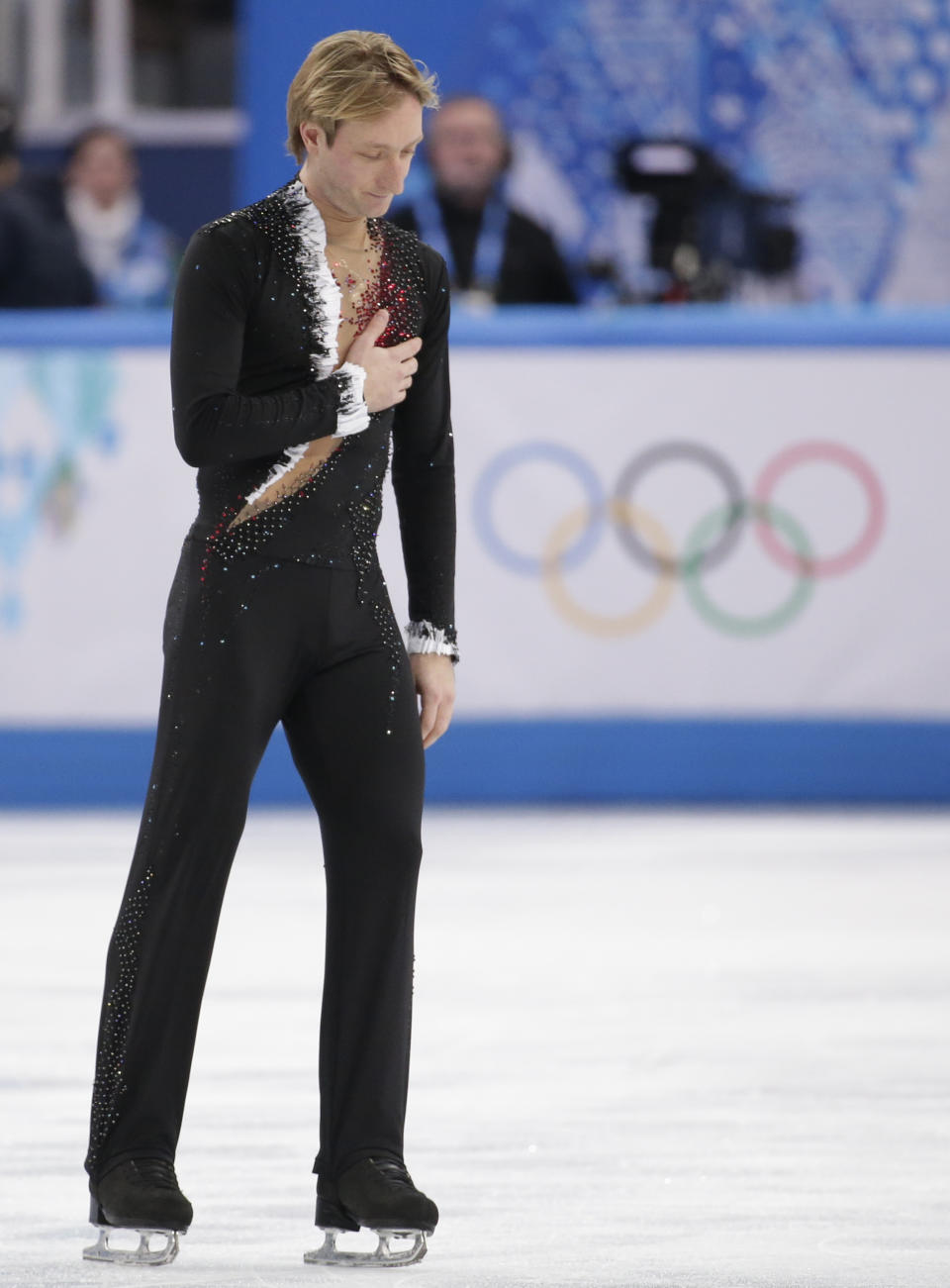 Evgeni Plushenko of Russia acknowledges the crowd as he leaves the ice after pulling out of the men's short program figure skating competition due to illness at the Iceberg Skating Palace during the 2014 Winter Olympics, Thursday, Feb. 13, 2014, in Sochi, Russia. (AP Photo/Bernat Armangue)