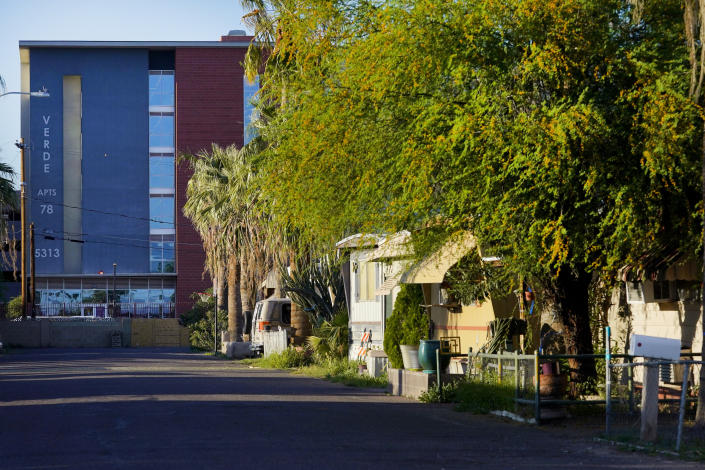 Grand Canyon University's Verde Apartments rise above the Periwinkle Mobile Home Park, Thursday, April 11, 2023, in Phoenix. Residents of the park are facing an eviction deadline of May 28 due to the private university's plan to redevelop the land for student housing. (AP Photo/Matt York)