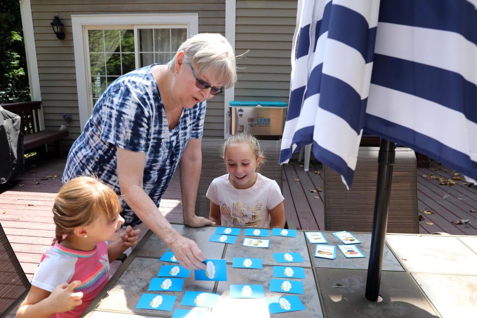 Yonkers, N.Y., elementary school teacher Irene Bordes, 66, of Cortlandt Manor made the decision to retire early because of her concerns with COVID-19 and to help her son and daughter-in-law with child care for her three grandchildren. Bordes plays a memory card game with her granddaughters Sammie, 5, and Charlotte, 8, at her family's home in Yorktown Heights Aug. 26, 2020.