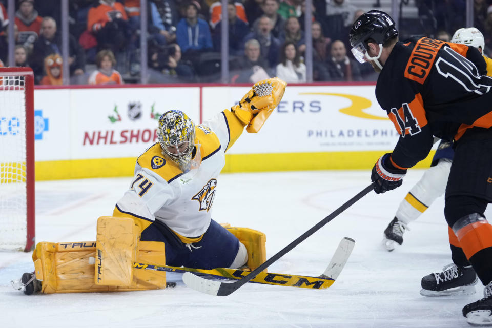 Nashville Predators' Juuse Saros (74) cannot stop a goal by Philadelphia Flyers' Sean Couturier (14) during the second period of an NHL hockey game, Thursday, Dec. 21, 2023, in Philadelphia. (AP Photo/Matt Slocum)