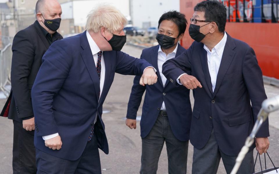 Boris Johnson (left) meets wind farm project investors in Fraserburgh Harbour, Aberdeenshire, as he journeys to the Moray Offshore Windfarm East - PA