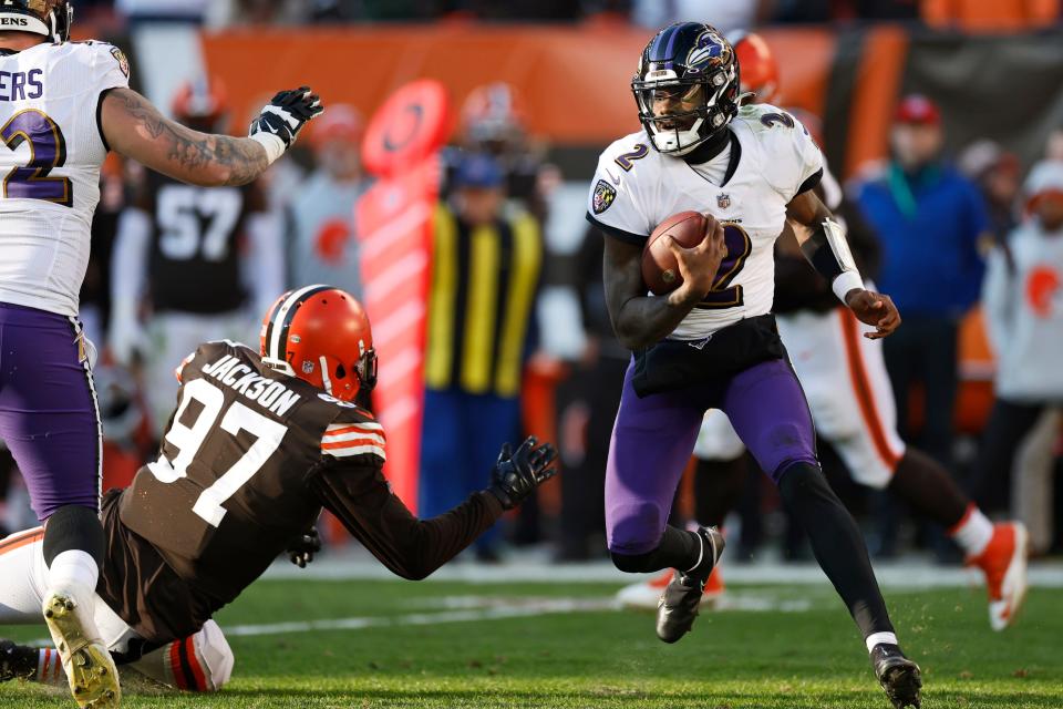 Baltimore Ravens quarterback Tyler Huntley (2) scrambles against Cleveland Browns defensive tackle Malik Jackson (97) during the second half of an NFL football game, Sunday, Dec. 12, 2021, in Cleveland. (AP Photo/Ron Schwane)