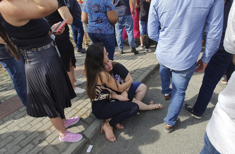 Women sit in an embrace outside the "Cantinho do Bom Pastor" daycare center after a fatal attack on children, in Blumenau, Santa Catarina state, Brazil, Wednesday, April 5, 2023. A man with a hatchet jumped over a wall and invaded the daycare center, killing four children and wounding at least five others, authorities said. (Patrick Rodrigues/Portal NSC Total via AP)