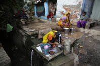 <p>A woman takes a bath at a roadside community tap as others wait their turn in Allahabad, India, Friday, May 27, 2016. People in poor neighborhoods in different cities in India often rely on communal taps for their daily water needs as water connections to every home are still unavailable. (AP Photo/Rajesh Kumar Singh) </p>
