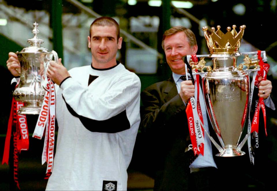 Manchester United's star striker Eric Cantona (left) with the FA Cup and manager Alex Ferguson with the Carling Premiership trophy on their victorious return to Manchester's Victoria Station Sunday May 12 1996. (AP Photo /Peter Wilcock/PA)