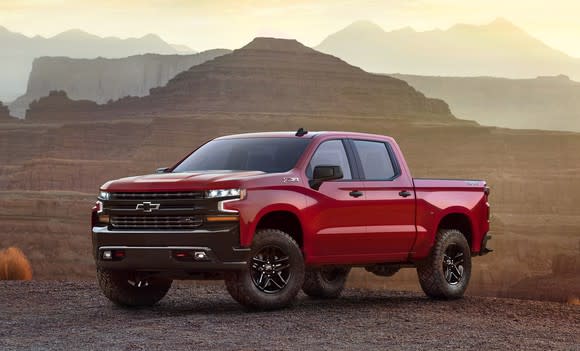 A red 2019 Chevrolet Silverado LT Trailboss, a four-door off-road pickup truck, on rugged desert terrain.