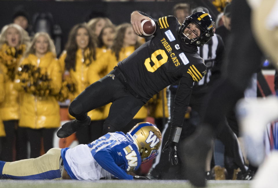 Winnipeg Blue Bombers' Winston, bottom, Rose tackles Hamilton Tiger-Cats quarterback Dane Evans during first-half football game action in the Grey Cup in Calgary, Alberta, Sunday, Nov. 24, 2019. (Nathan Denette/The Canadian Press via AP)