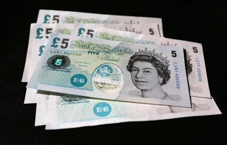 Sample polymer five GB pound banknotes are seen on display at the Bank of England in London September 10, 2013. REUTERS/Chris Ratcliffe/pool