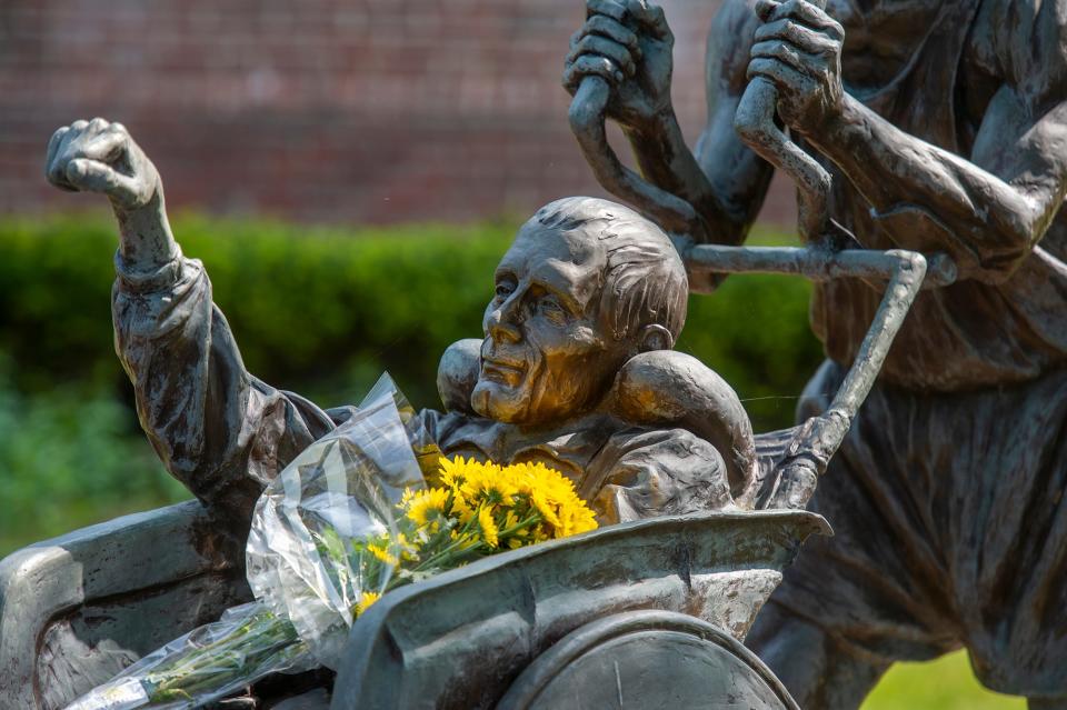 Flowers placed on the statue of Boston Marathon legends Dick and Ricky Hoyt outside the Center School in Hopkinton, May 23, 2023. Rick died Monday at the age of 61.