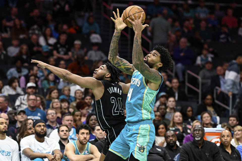Charlotte Hornets center Nick Richards (4) and Brooklyn Nets guard Cam Thomas (24) battle for a loose ball during the first half of an NBA basketball game, Saturday, March 9, 2024, in Charlotte, N.C. (AP Photo/Matt Kelley)