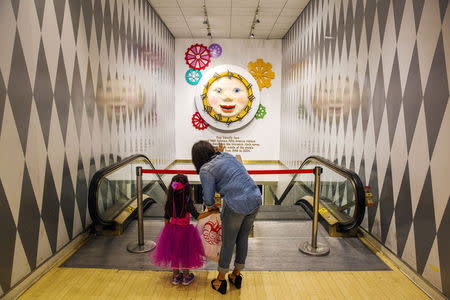 A woman and her daughter look at a clock that once hung in the main entryway of the store inside toy store FAO Schwarz on the last day that the store will be open in New York, July 15, 2015. REUTERS/Lucas Jackson