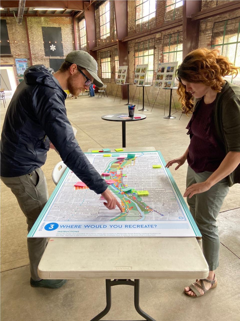 Thomas Hill and Maria Wainscott survey a map of a Whitewater Gorge Park section Thursday, April 28, 2022, inside the Starr-Gennett Building.