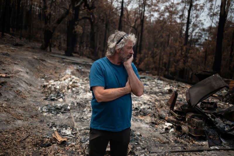 Australian surfer David Ford stands next to a burnt shed where he kept his vintage surfboard collection that was destroyed in the recent bushfires in Lake Conjola