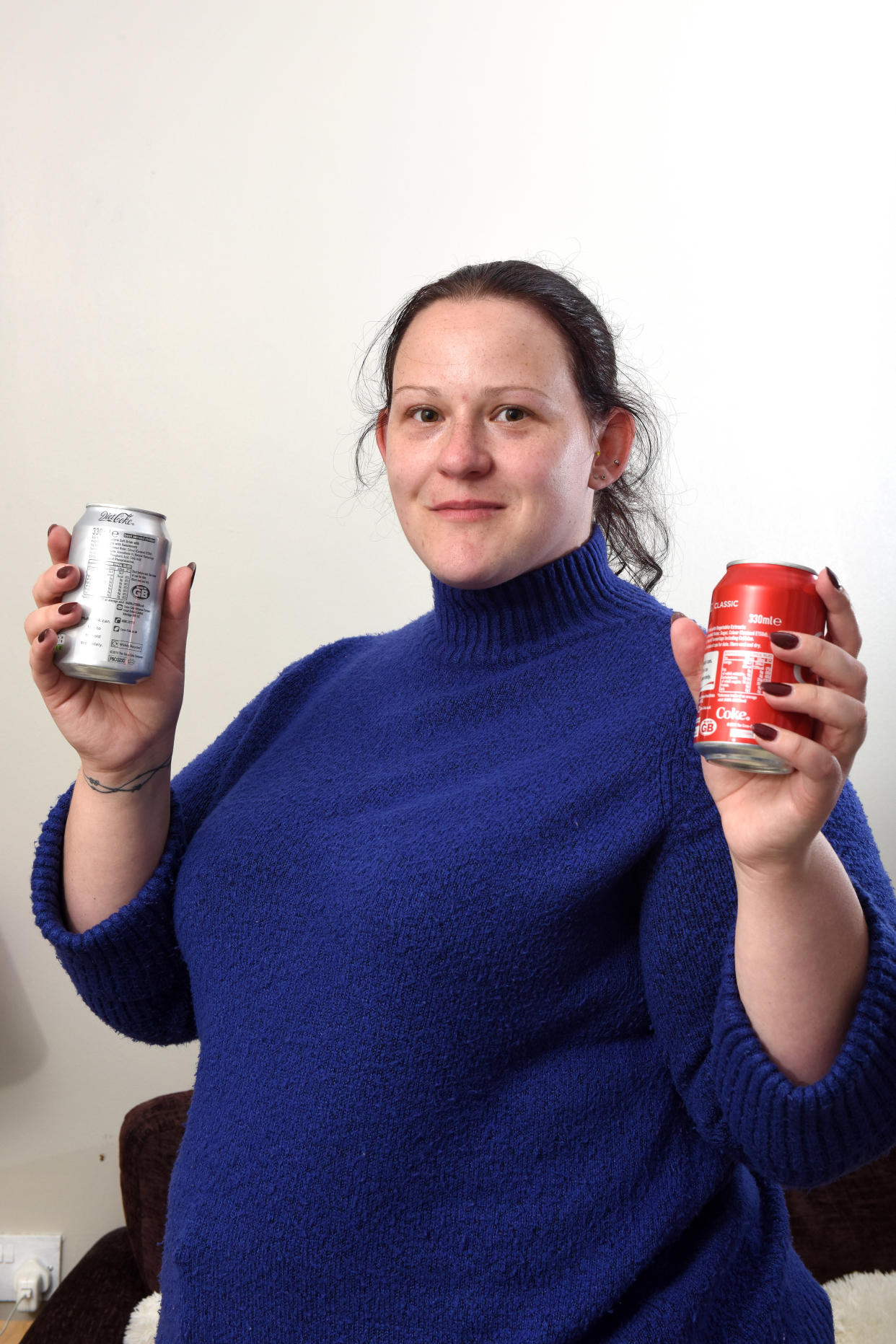 Elizabeth Perkins with two a can of diet cola which she is allergic to and a can of regular cola which she can have. [Photo: Caters]