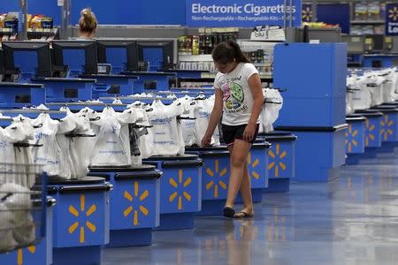 A girl walks along the checkouts at the Wal-Mart Supercenter in Springdale, Arkansas June 4, 2015. REUTERS/Rick Wilking