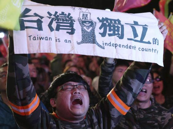 Supporters of Ms Tsai brandish a banner declaring Taiwan's independence from China (AP)