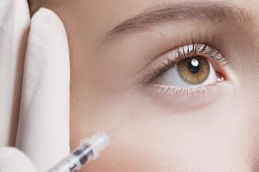 Close up of woman receiving botox injection under eye