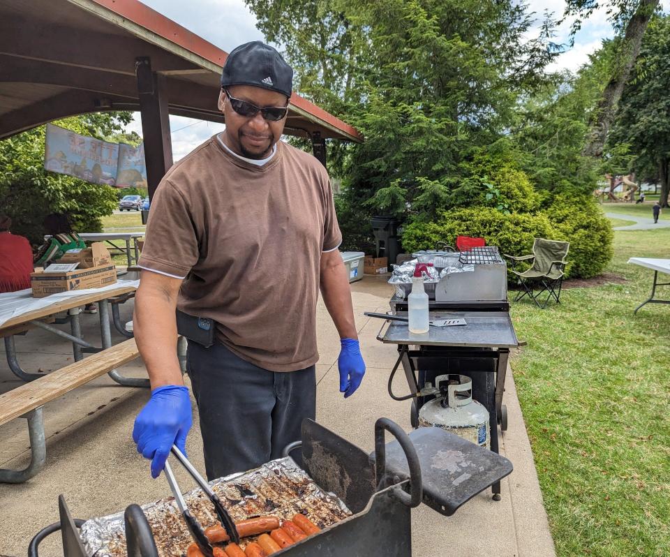 Joseph Singleton grills hot dogs at a reunion of former residents of Lafayette Street SE in Canton. The reunion, held in North Canton's Price Park, gave the former residents a chance to reminisce about their former close-knit community.
