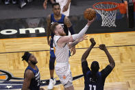 Orlando Magic forward Ignas Brazdeikis (17) shoots between Minnesota Timberwolves forward Josh Okogie (20), guard D'Angelo Russell, rear, and center Naz Reid (11) during the second half of an NBA basketball game Sunday, May 9, 2021, in Orlando, Fla. (AP Photo/Phelan M. Ebenhack)