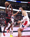 Chicago Bulls' Ayo Dosunmu (12) drives to the basket past Washington Wizards' Jordan Poole as Patrick Baldwin Jr. also defends during the second half of an NBA basketball game Monday, March 25, 2024, in Chicago. The Wizards won 107-105. (AP Photo/Charles Rex Arbogast)