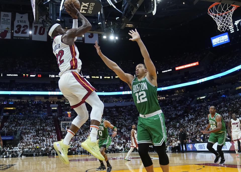 Miami Heat forward Jimmy Butler (22) aims to score as Boston Celtics forward Grant Williams (12) defends during the second half of Game 2 of the NBA basketball Eastern Conference finals playoff series, Thursday, May 19, 2022, in Miami. (AP Photo/Lynne Sladky)