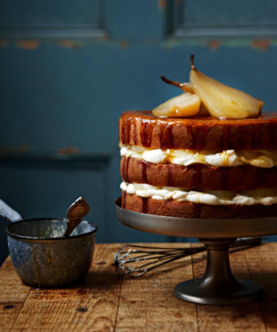 A chocolate pear cake on a wooden cake stand