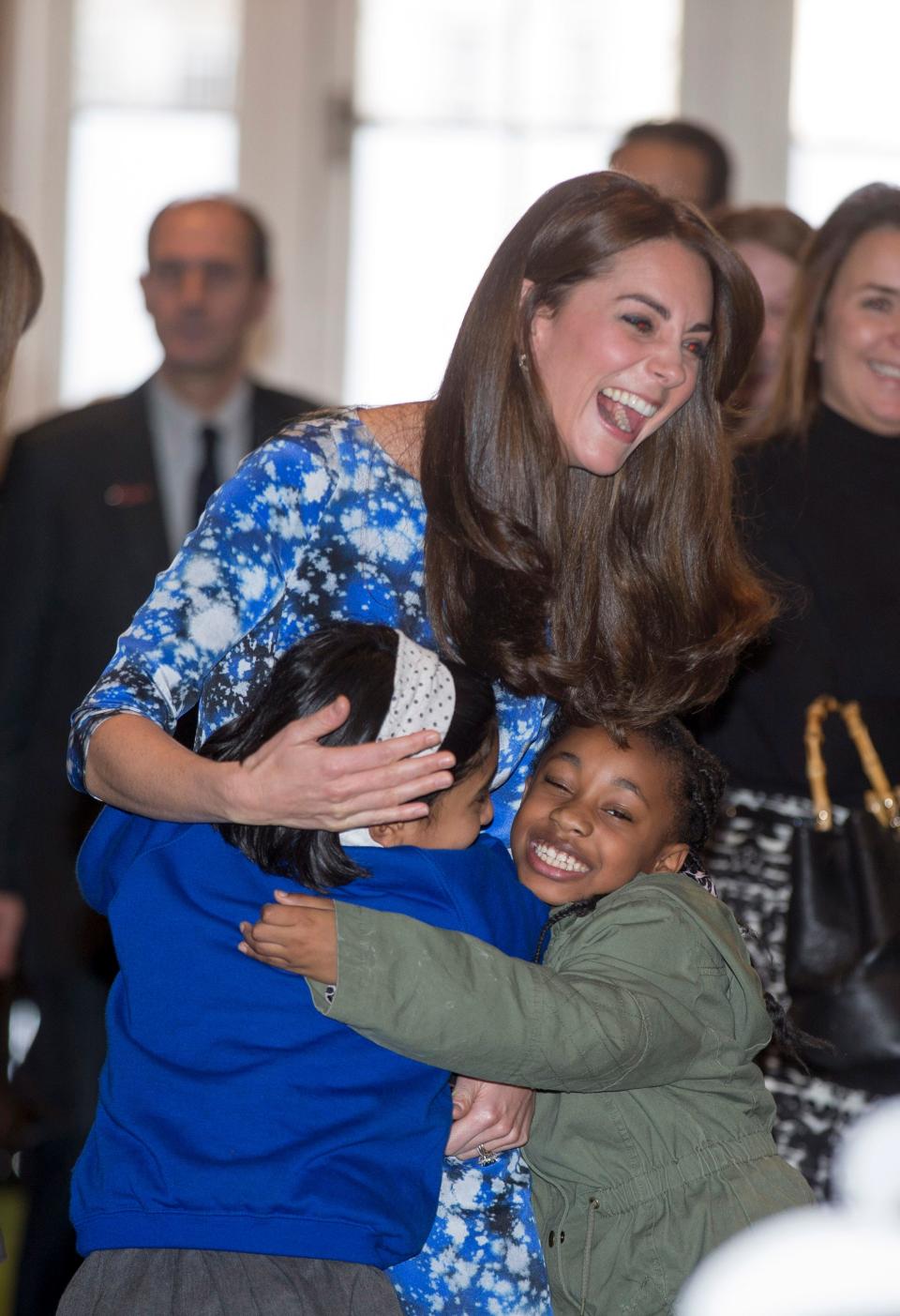Kate Middleton hugs two children in 2015.