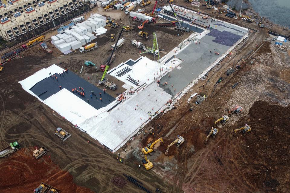 This aerial photo shows excavators and trucks at the construction site of a new hospital being built to treat patients from a deadly virus outbreak in Wuhan in China's central Hubei province on January 27, 2020. - China is rushing to build a new hospital in a staggering 10 days to treat patients at the epicentre of a deadly virus outbreak that has stricken thousands of people, state media reported on January 24. (Photo by Hector RETAMAL / AFP) (Photo by HECTOR RETAMAL/AFP via Getty Images)