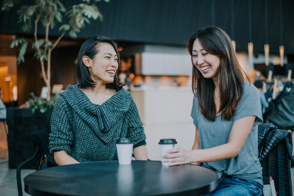 Two Asian women enjoying cups of coffee