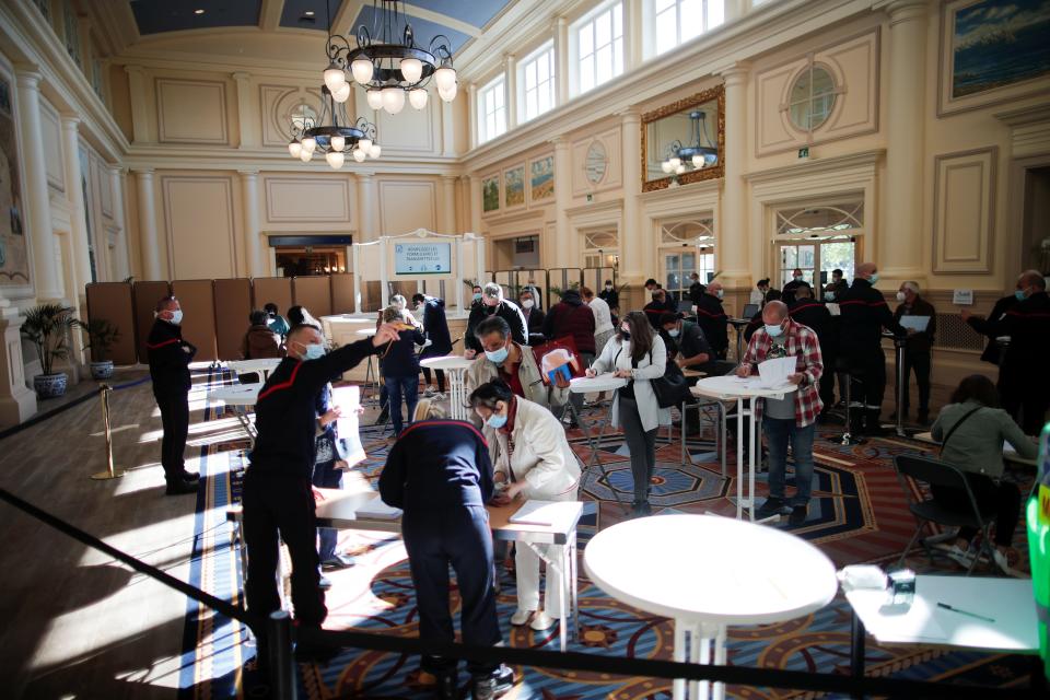 People register to receive a dose of the "Comirnaty" Pfizer BioNTech COVID-19 vaccine at the Disneyland Paris theme park vaccination center in Marne-la-Vallee, near Paris, as part of the coronavirus disease (COVID-19) vaccination campaign in France, April 24, 2021.