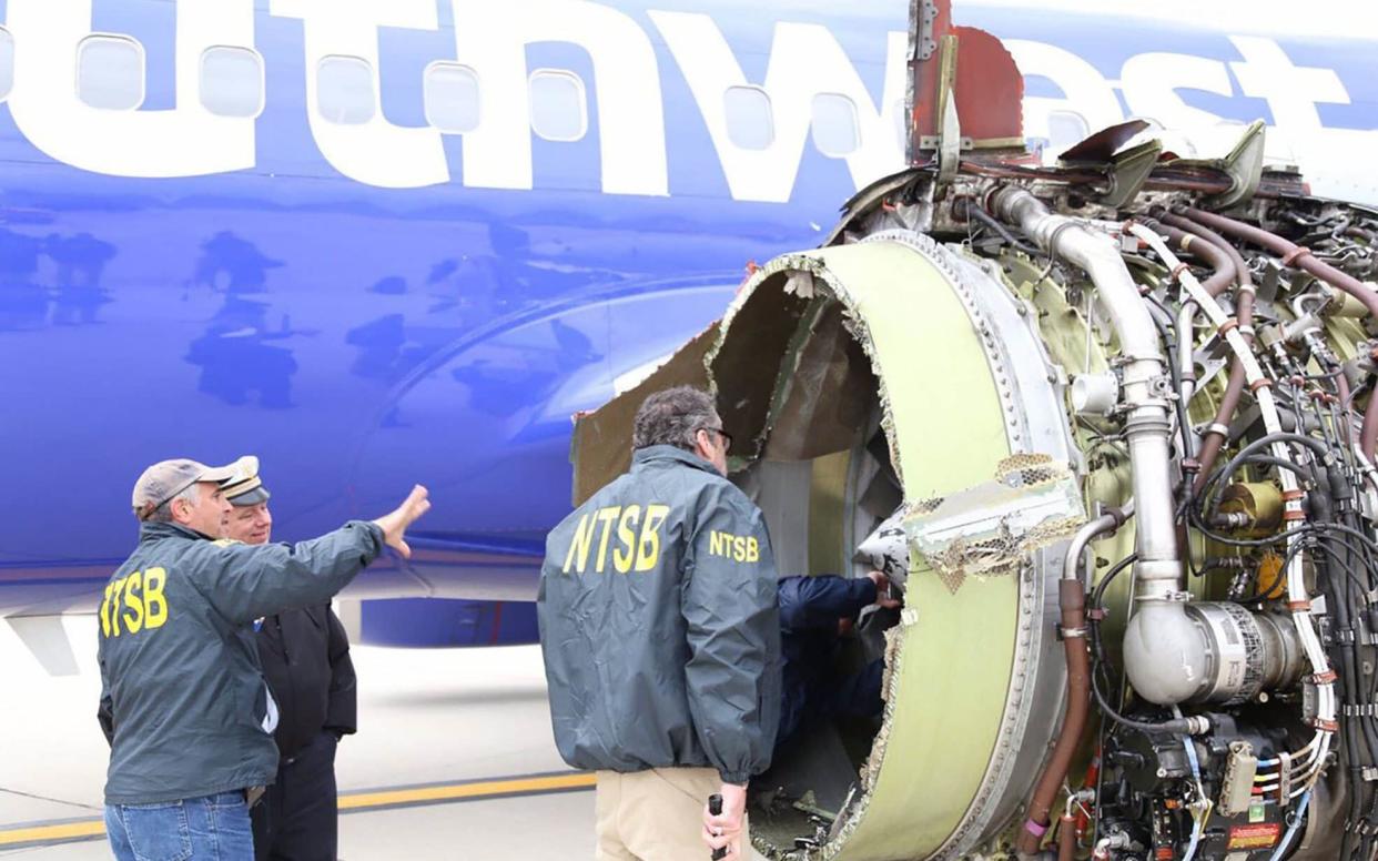 Investigators examine the damage to the engine of the Southwest Airlines plane - AFP