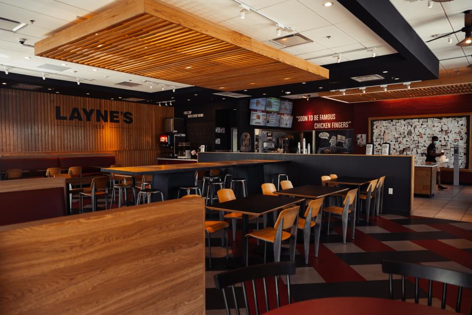 A fast food restaurant interior with light wood panels and red walls.