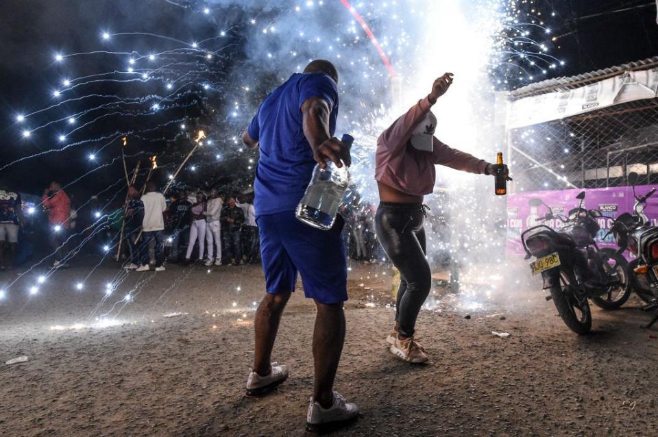 People dance as fireworks blow up during the "Adoraciones al Nino Dios" celebrations in Quinamayo