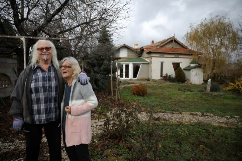 Waldemar Hackstaetter and his wife Hildegard pose for a picture in front of their house in the village of Sirakovo