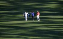 Rory McIlroy of Northern Ireland (C) walks up the second fairway with Toto Gana of Chile (R) during Tuesday practice rounds for the 2017 Masters at Augusta National Golf Course in Augusta, Georgia, U.S., April 4, 2017. REUTERS/Mike Segar