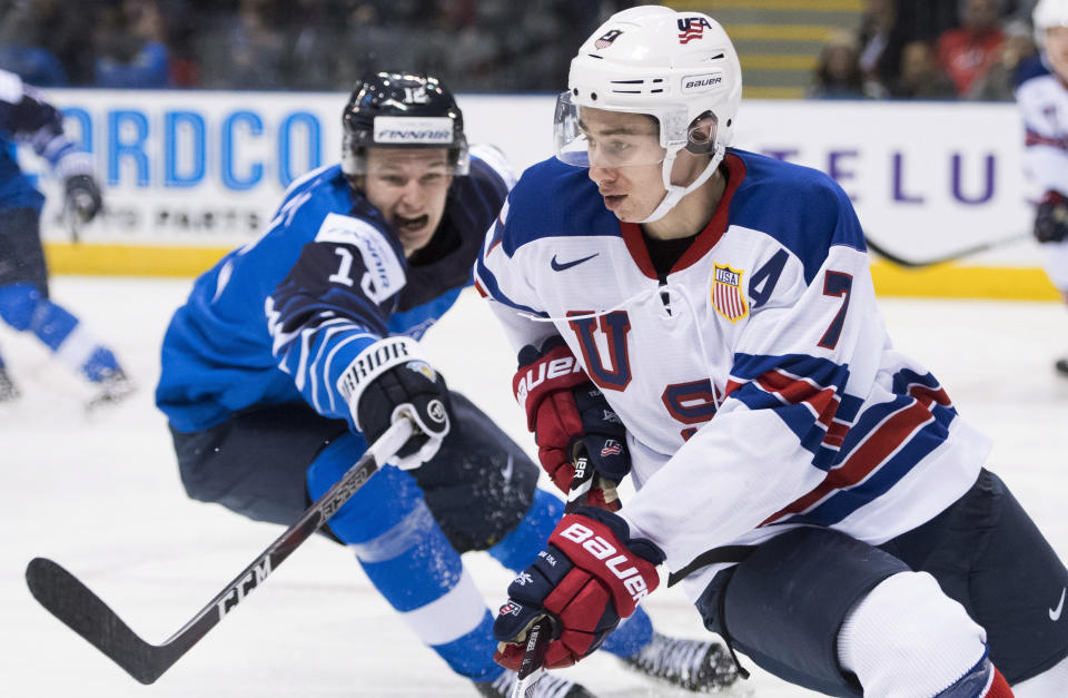 United States' Quinn Hughes (7) is defended by Finland's Samuli Vainionpaa (12) during the third period of a world junior hockey championships game in Victoria, British Columbia, Monday, Dec. 31, 2018. (Jonathan Hayward/The Canadian Press via AP)