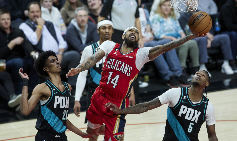 New Orleans Pelicans forward Brandon Ingram, center, shoots between Portland Trail Blazers forwards John Butler Jr., left, and Cam Reddish during the second half of an NBA basketball game in Portland, Ore., Monday, March 27, 2023. (AP Photo/Craig Mitchelldyer)