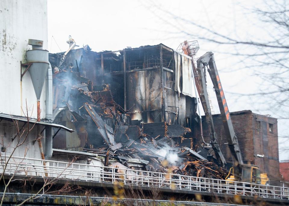 The remains of the former Star of the West mill complex in Kent continues to smolder and burn Saturday, 24 hours after the start of a blaze.