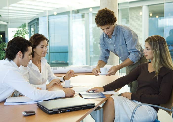 An employee giving coffee to his colleagues