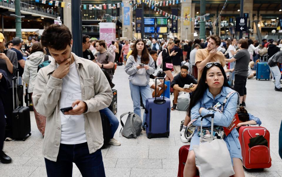 People stand on a crowded station concourse