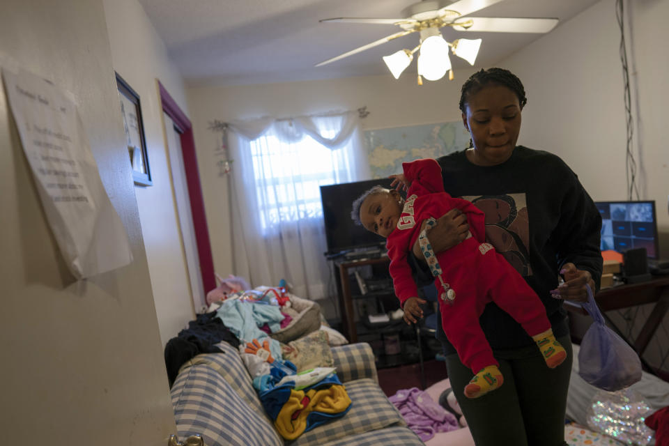 Ansonia Lyons carries her son, Adrien Lyons, after a diaper change, Saturday, Feb. 5, 2022, in Birmingham, Ala. (AP Photo/Wong Maye-E)