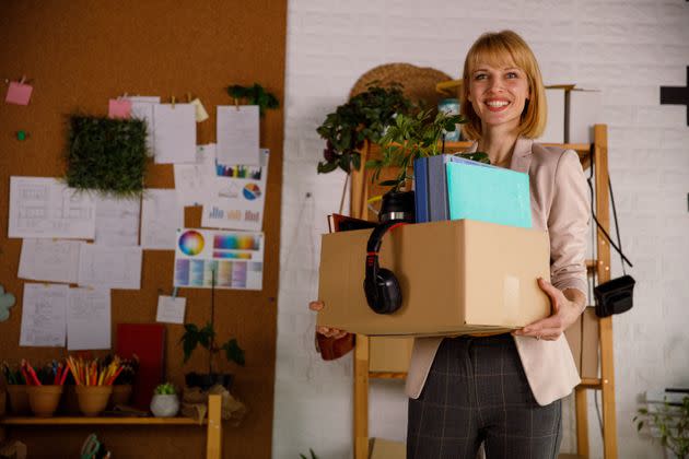 Copy space shot of confident mid adult businesswoman holding a carboard box with her personal belongings and office supplies while standing in her new office after getting hired. (Photo: fotostorm via Getty Images)