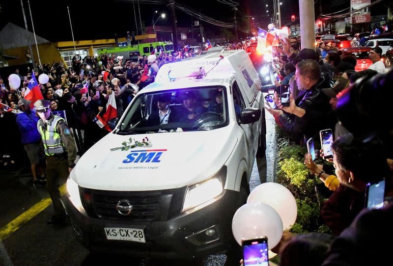 Personas saludan el vehículo que transporta el cuerpo del fallecido expresidente Sebastián Piñera en Valdivia, Chile