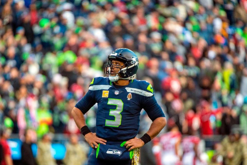 Seattle Seahawks quarterback Russell Wilson (3) looks up at the video board as a play in reviews by the officials during the third quarter of an NFL game against the Arizona Cardinals on Sunday afternoon at Lumen Field in Seattle. The referee crew was reviewing the interception and return by Seattle Seahawks cornerback Sidney Jones (23). The interception was overruled by the officials and Arizona was retained possession of the ball.