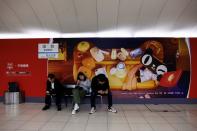 People sit near an Alibaba's advertisement promoting Singles Day shopping festival, in Beijing