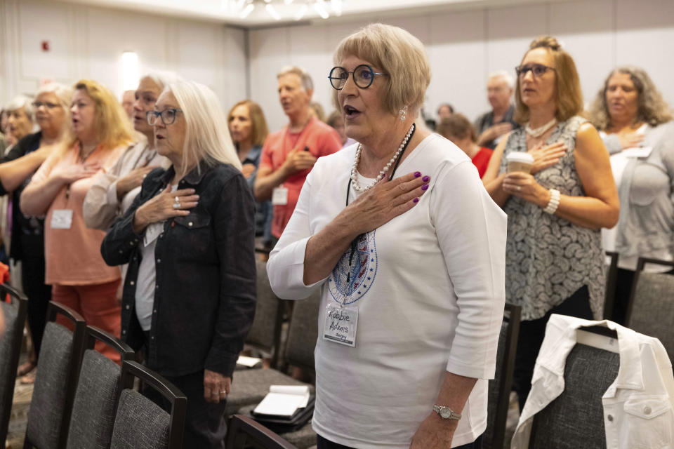 Robbie Adams of Sarpy County, Neb., recites the Pledge of Allegiance with fellow attendees to open the Nebraska Election Integrity Forum on Saturday, Aug. 27, 2022, in Omaha, Neb. (AP Photo/Rebecca S. Gratz)