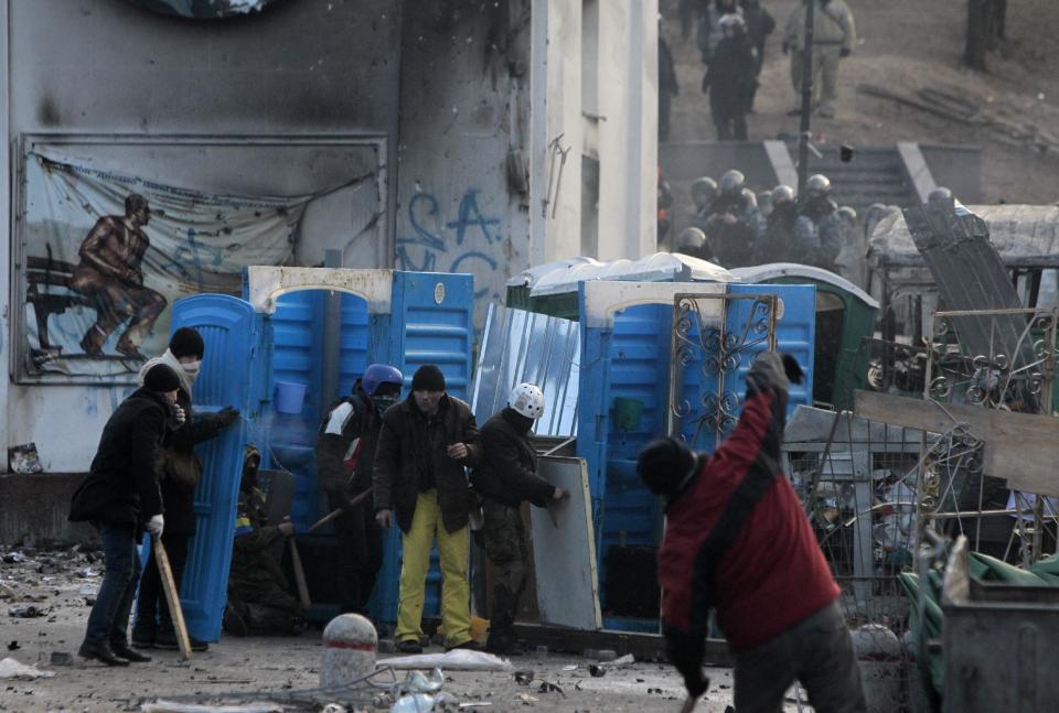 Protesters clash with police in central Kiev, Ukraine, Monday, Jan. 20, 2014. Protesters erected barricades in Kiev as the sound of stun grenades pierce the freezing air, after a night of rioting and street protests. (AP Photo/Sergei Chuzavkov)