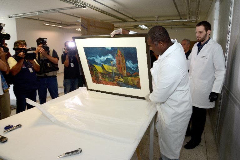 Experts at the Oscar Niemeyer Museum in Brazil, show one of the works of art seized by the police from individuals involved in the corruption scandal rocking the state oil giant Petrobras, on March 19, 2015