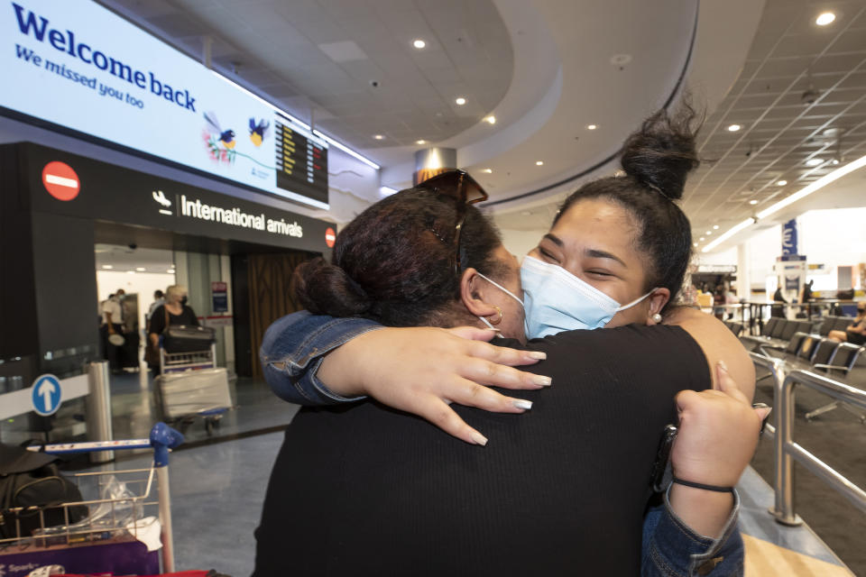 Two women embrace after one arrives on a flight from Australia at Auckland International Airport in Auckland, New Zealand on Feb. 26, 2022. New Zealand is ending a requirement that incoming travelers isolate themselves as it continues to dismantle its coronavirus border protections in the face of a growing domestic outbreak. (Brett Phibbs/New Zealand Herald via AP)