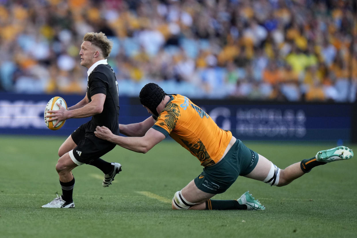 New Zealand's Damian McKenzie, left, is tackled by Australia's Nick Frost during their rugby union test match in Sydney, Saturday, Sept. 21, 2024. (AP Photo/Rick Rycroft)